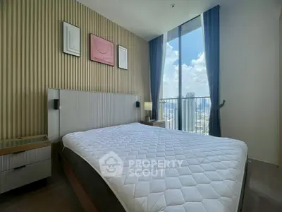 Modern bedroom with large window offering stunning city view