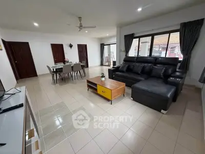 Spacious living room with modern furniture and dining area, perfect for family gatherings.