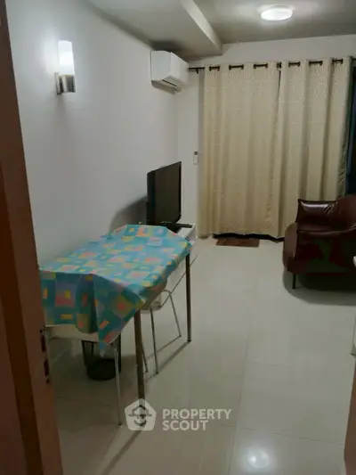 Cozy living room with modern furniture and air conditioning, perfect for relaxation.