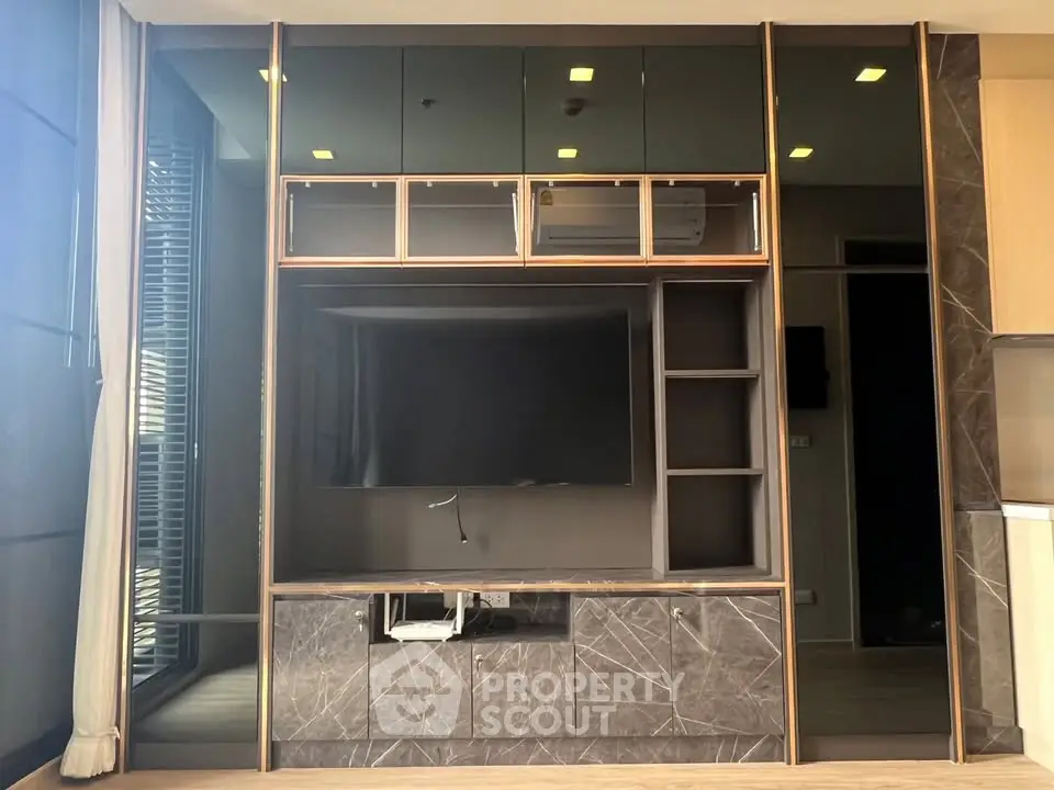 Modern living room with sleek built-in entertainment center and large window for natural light.