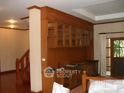 Spacious living room with elegant wooden cabinetry and staircase in a modern home