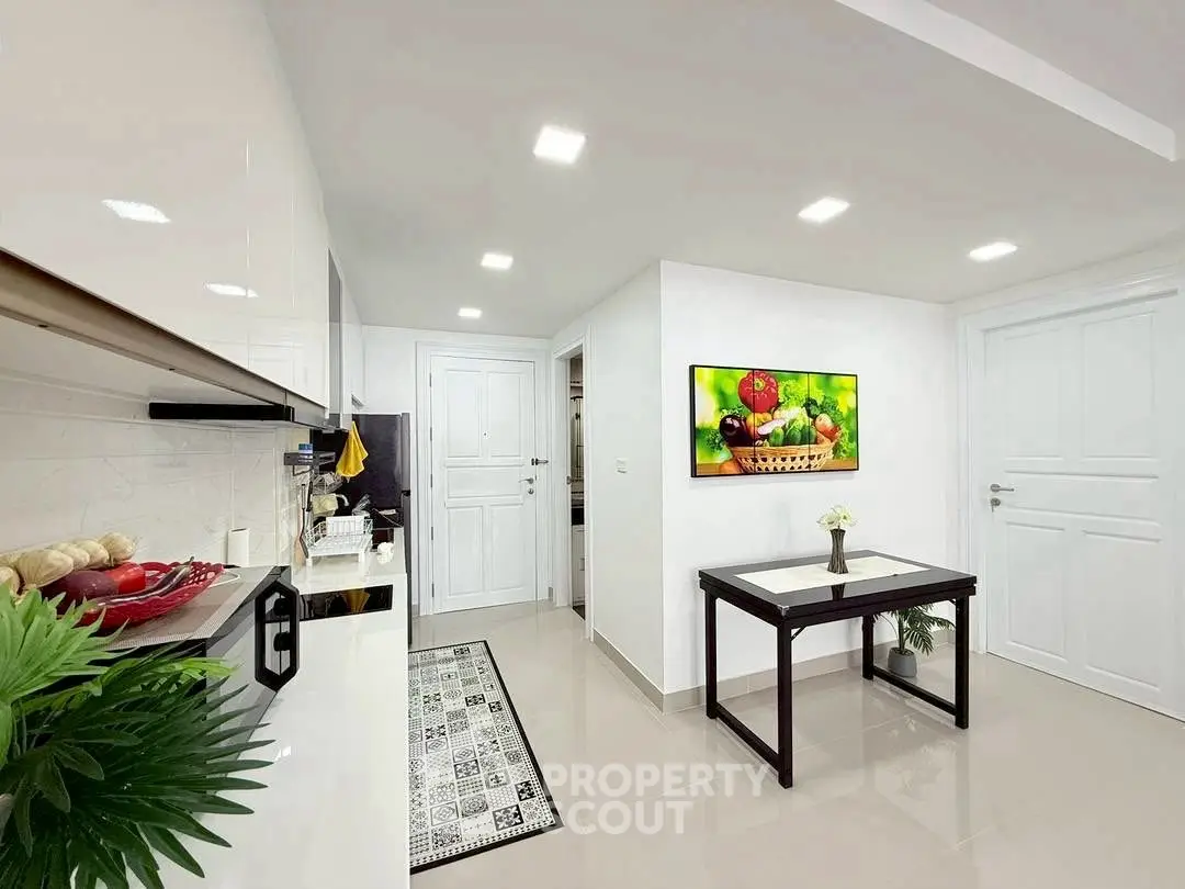 Modern kitchen with sleek white cabinets and vibrant fruit artwork