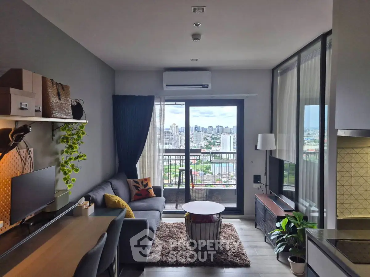 Modern living room with city view, stylish decor, and balcony access in high-rise apartment.