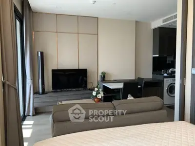 Modern living room with sleek furniture and integrated kitchen appliances in a stylish apartment.