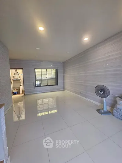 Spacious unfurnished room with tiled flooring and ceiling lights, ideal for customization.