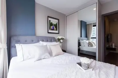 Modern bedroom with elegant decor and large mirror closet doors in a stylish apartment.