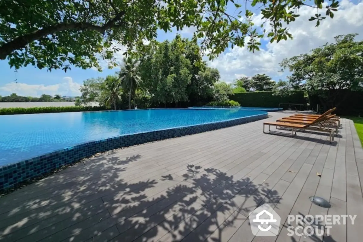 Luxurious outdoor pool area with sun loungers and lush greenery, perfect for relaxation and leisure.