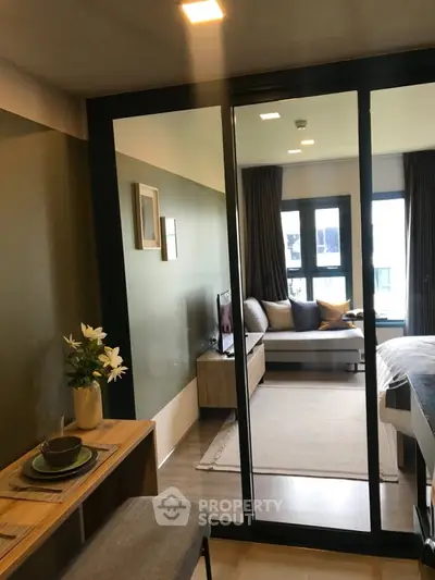 Modern studio apartment with glass partition, cozy living area, and stylish decor.