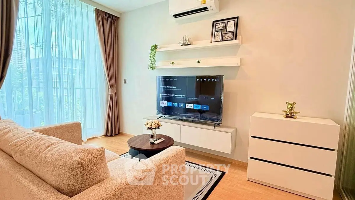 Modern living room with cozy sofa, wall-mounted TV, and stylish decor in bright apartment.