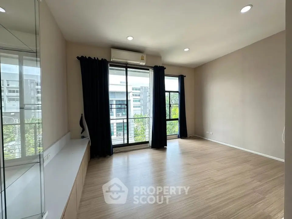 Spacious living room with large windows and modern flooring in a high-rise apartment.