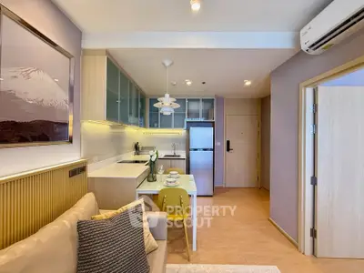 Modern open-layout kitchen and living area with stylish decor and natural lighting.