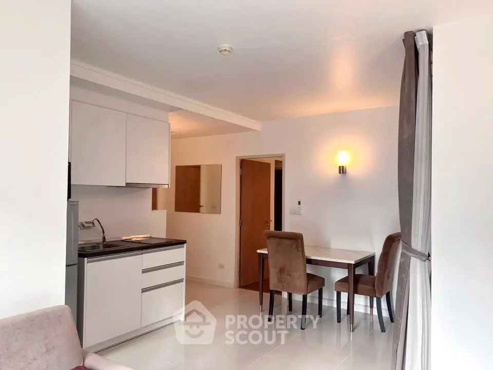 Modern open-plan living and dining area with sleek kitchen design.