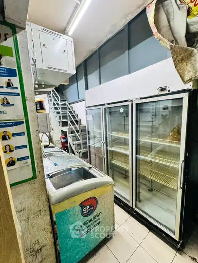 Commercial space with refrigeration units and storage area, ideal for retail or food business.