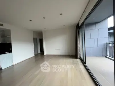 Spacious living room with modern open layout, large windows allowing ample natural light, and direct balcony access, perfect for entertaining and relaxation.