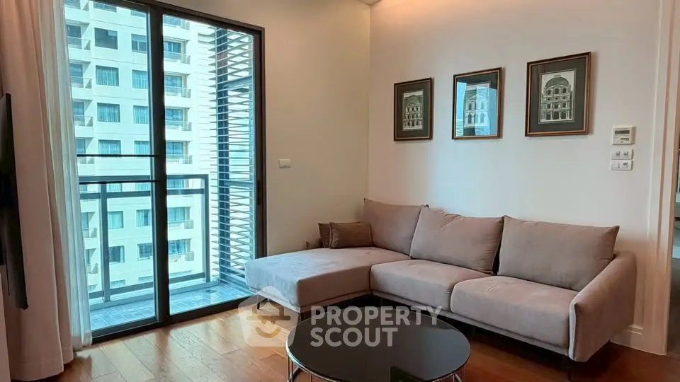 Modern living room with cozy sofa and city view balcony in high-rise apartment.