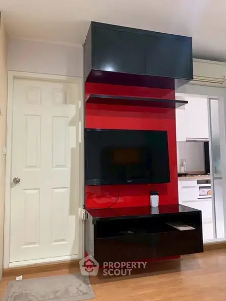 Modern living room with sleek TV unit and vibrant red accent wall