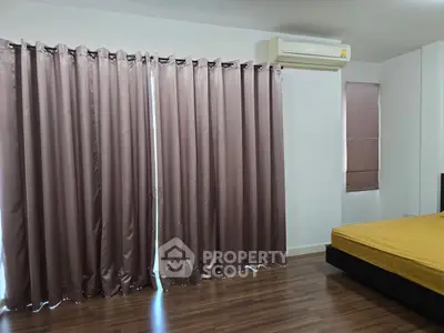 Spacious bedroom with elegant curtains and air conditioning, perfect for comfort and relaxation.