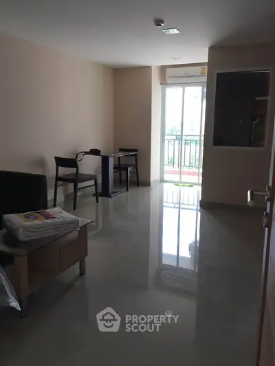 Spacious living room with glossy floors and balcony access in modern apartment.