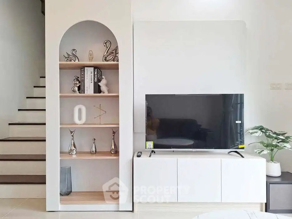 Modern living room with stylish shelving and flat-screen TV, perfect for contemporary living.