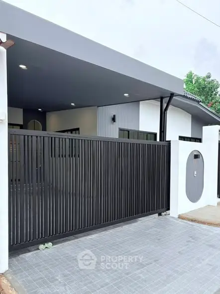 Modern house exterior with sleek gate and covered driveway