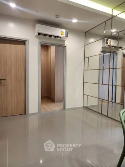 Modern interior with sleek mirrored wall and air conditioning, showcasing a stylish and spacious living area.