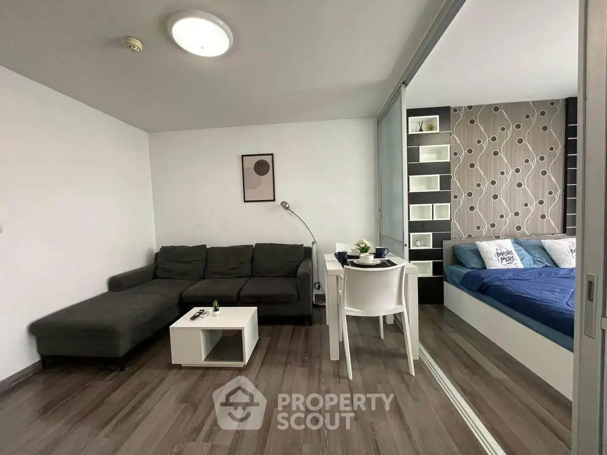 Modern studio apartment with stylish living area and cozy bedroom, featuring sleek furniture and contemporary decor.