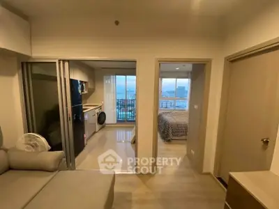 Modern apartment interior with open kitchen and cozy bedroom, featuring a stunning city view from the balcony.