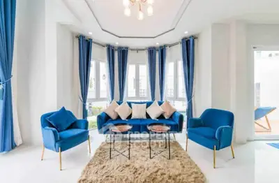 Elegant living room with blue furniture and large windows, perfect for relaxation.