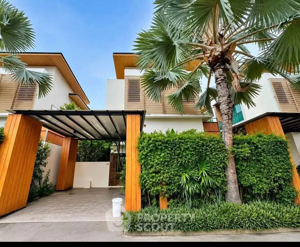 Modern tropical villa with lush greenery and wooden accents, featuring a spacious carport and contemporary design.
