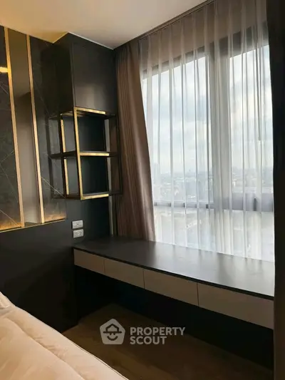 Modern bedroom with large window and stylish decor, offering a serene city view.