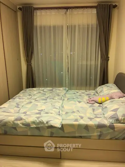 Cozy bedroom with modern decor and large window, perfect for relaxation.