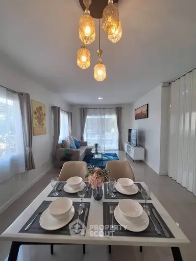 Spacious modern living room with elegant dining area and stylish lighting, perfect for entertaining guests.