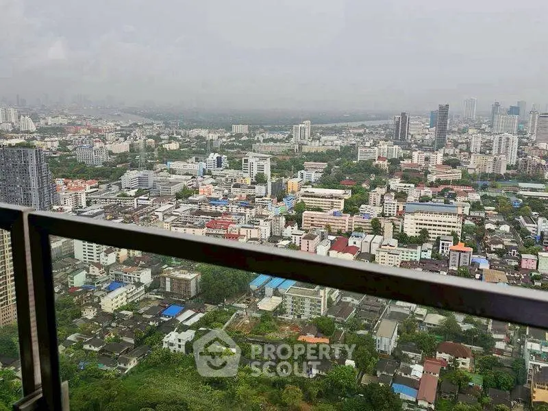 Stunning cityscape view from a high-rise balcony overlooking urban skyline and lush greenery.