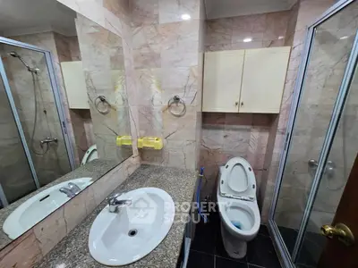 Luxurious marble bathroom with modern fixtures and spacious shower area