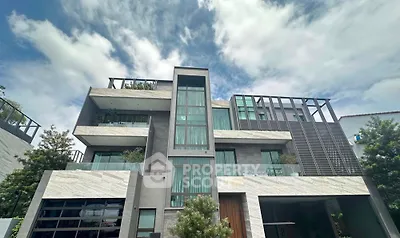 Modern multi-story building with sleek design and large windows under a cloudy sky.
