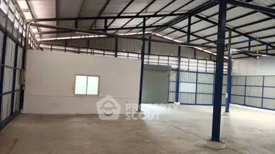 Spacious industrial warehouse with high ceilings and ample natural light.