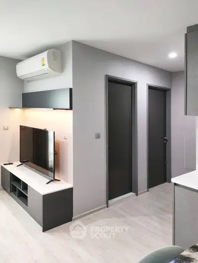 Modern living room with sleek design and wall-mounted TV in a stylish apartment.