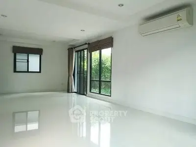 Spacious empty living room with large windows and air conditioning