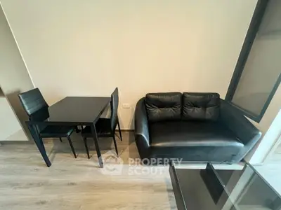 Modern living room with sleek black furniture and wooden flooring