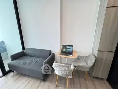 Modern living room with cozy gray sofa and stylish chairs, perfect for relaxation and work-from-home setup.