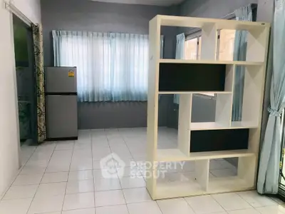 Spacious living area with modern shelving and natural light, perfect for stylish urban living.