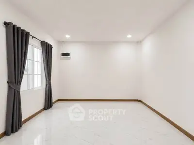 Spacious empty room with large window and elegant curtains, perfect for customization.