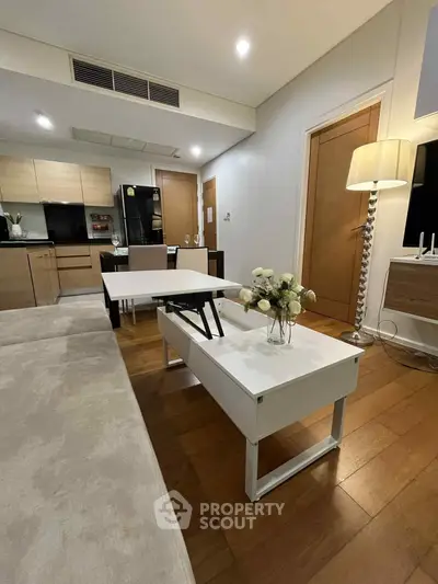 Modern living room with stylish furniture and open kitchen layout in a cozy apartment.