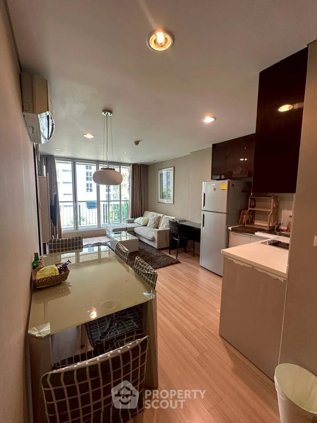 Modern open-layout living room and kitchen with stylish decor and natural light.