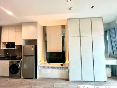 Modern studio apartment with sleek built-in storage and appliances, featuring a cozy living area and stylish decor.