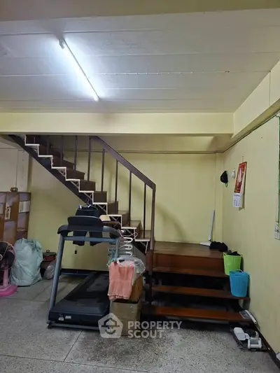 Spacious interior with staircase and treadmill, ideal for home gym setup.