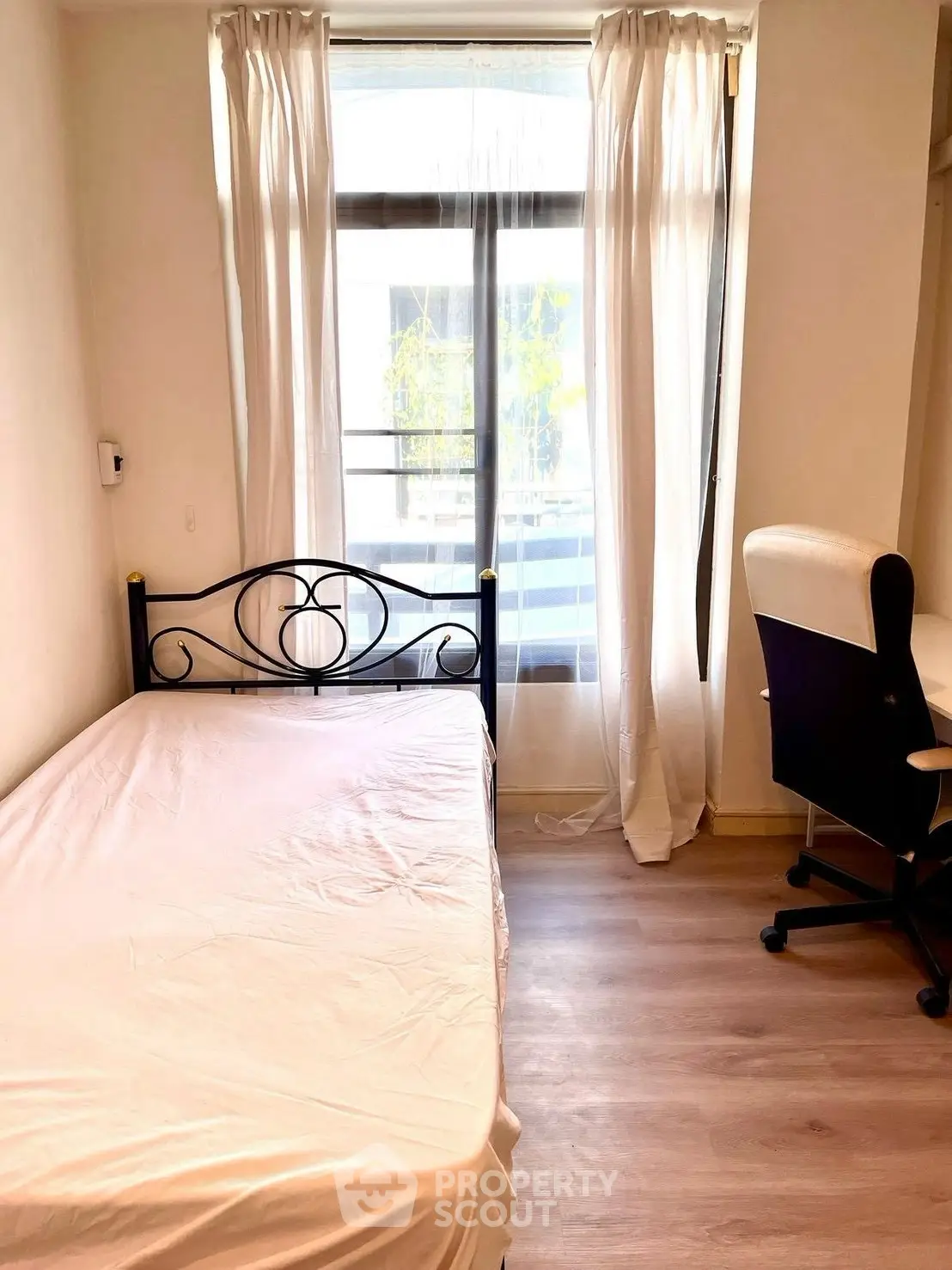 Cozy bedroom with single bed and study desk, bright natural light