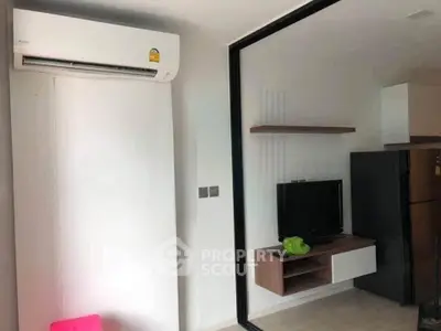Modern living room with air conditioning and sleek TV setup in a stylish apartment.