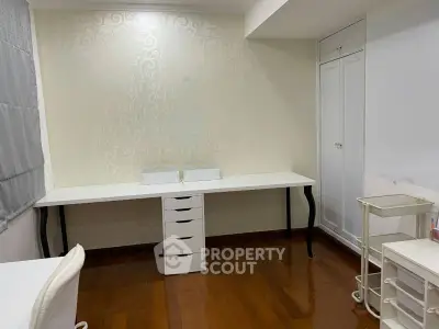 Spacious study room with elegant wallpaper and wooden flooring