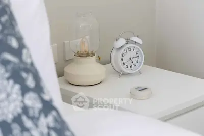 Cozy bedroom nightstand with vintage lamp and classic alarm clock
